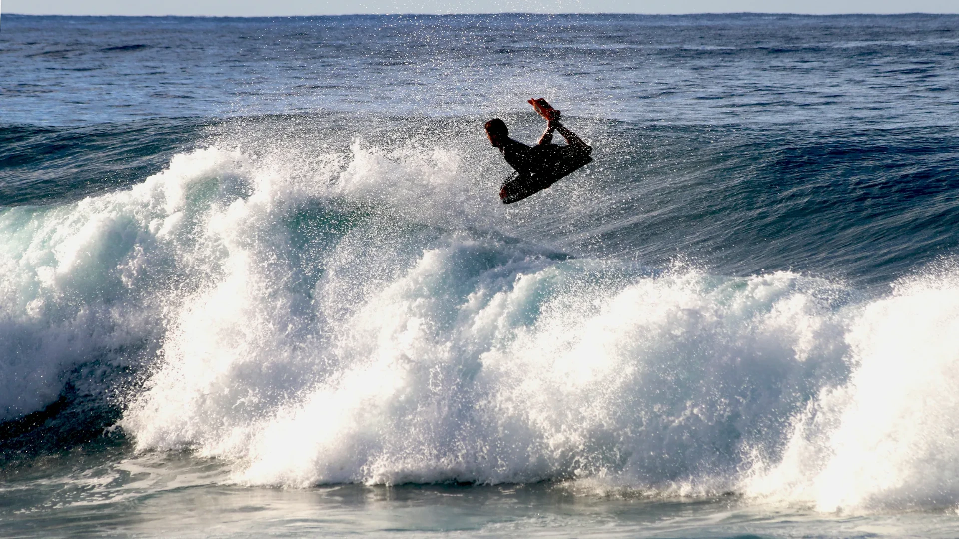 Atleta de bodyboarding em manobra aérea