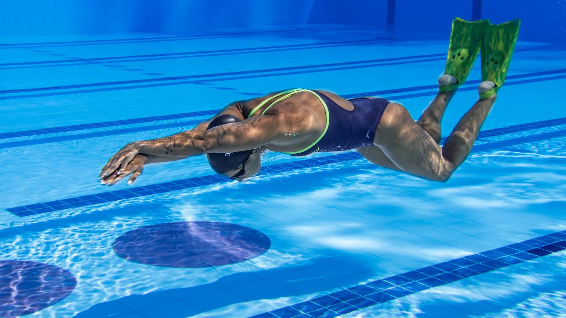 Nadador treinando com nadadeiras Kpaloa, visto de baixo na piscina