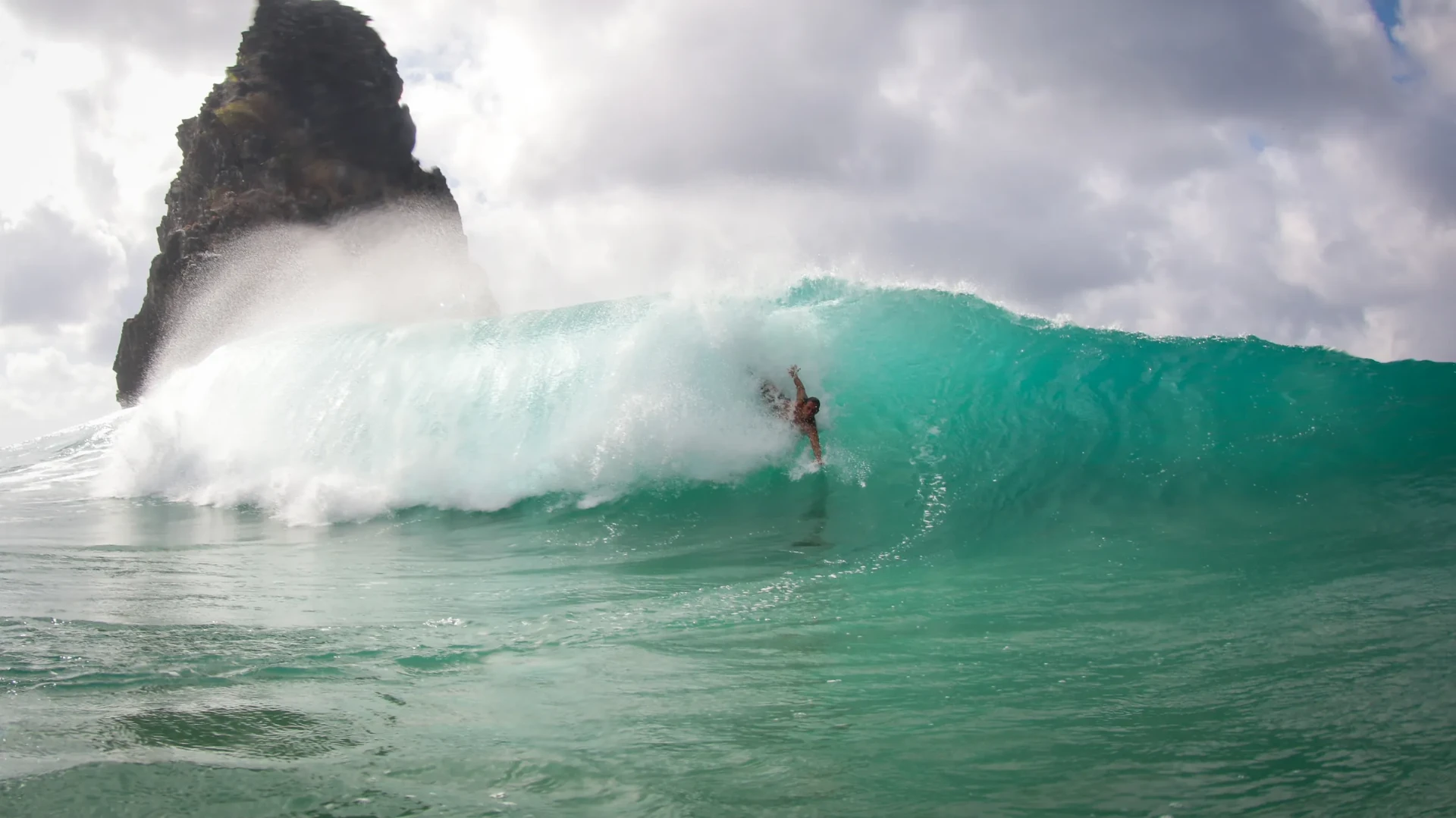 Bodysurfista deslizando em onda em Fernando de Noronha