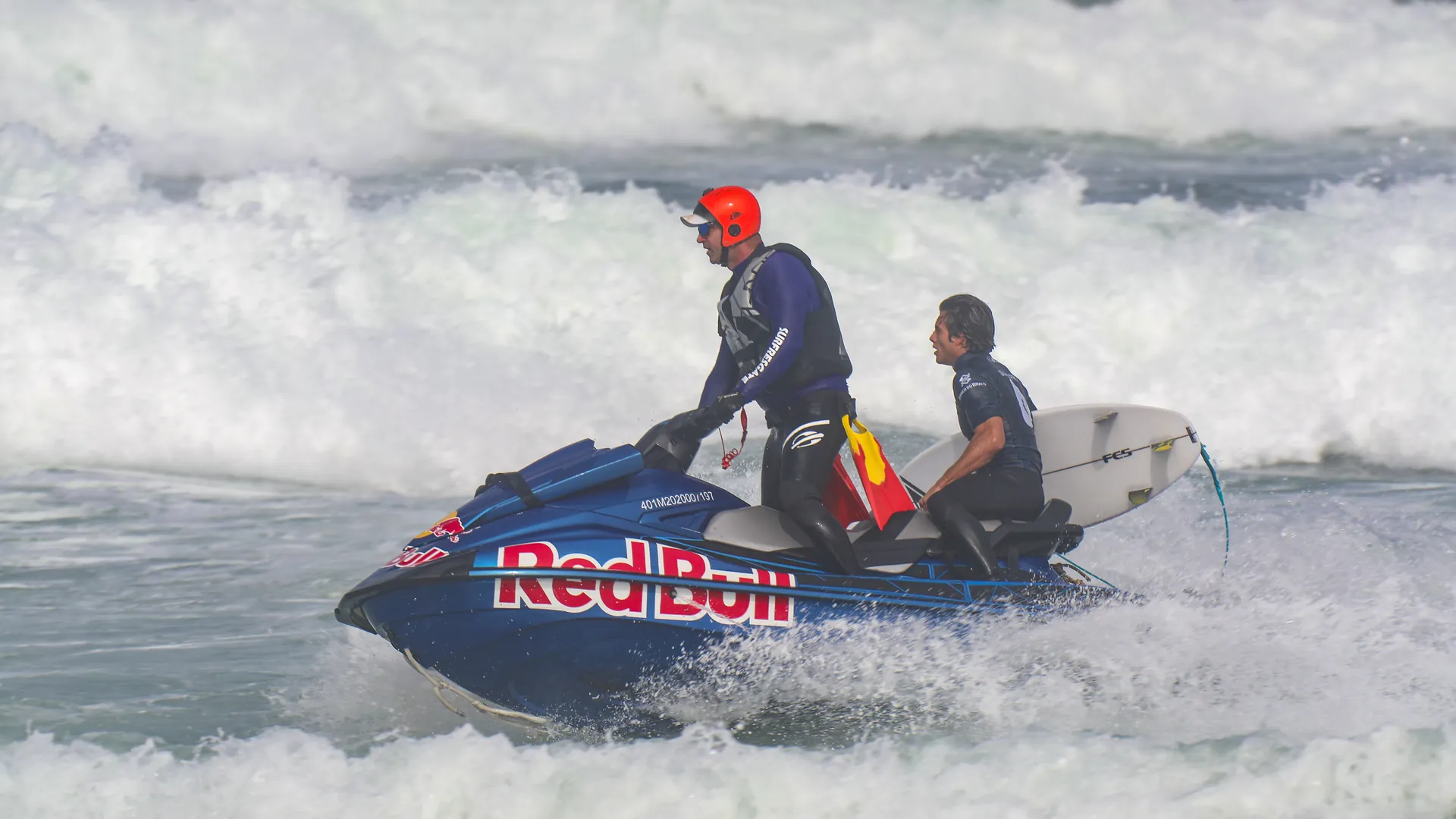 Resgatista leva um surfista no jet ski em mar agitado